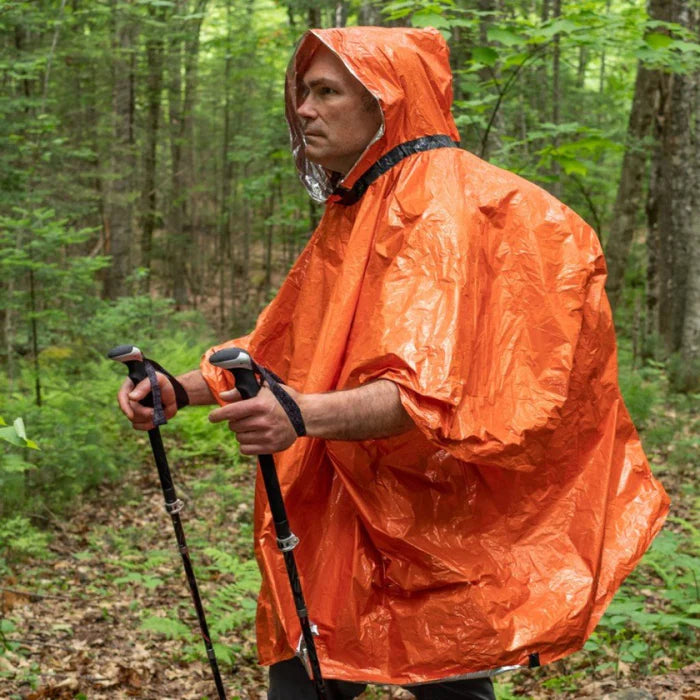 Heat_Reflective_Poncho_in_use_man_backpacking.webp